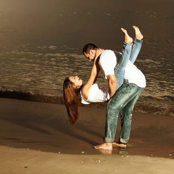 Young couple near the sea at sunrise