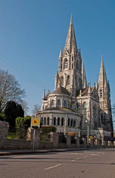 Saint Fin Barre&#039 s cathedral in Cork, Ireland (road view and blue sky background)