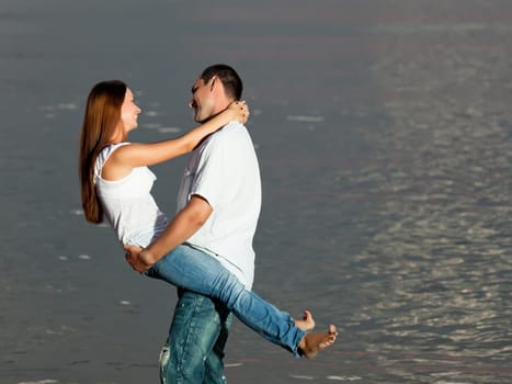 Young couple near the sea at sunrise