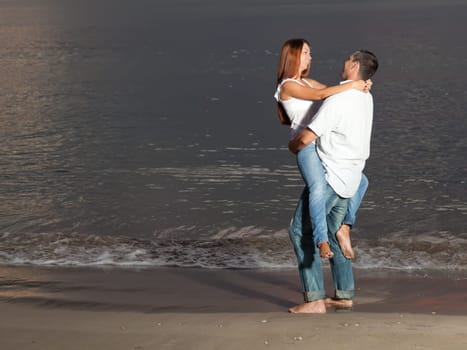 Young couple near the sea at sunrise