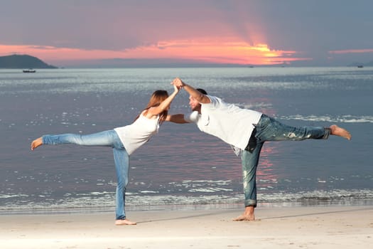 Young couple near the sea at sunrise