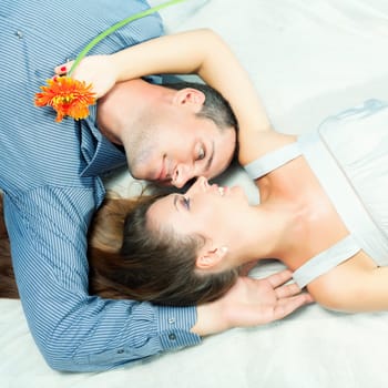 Portrait of young couple lies together outdoor
