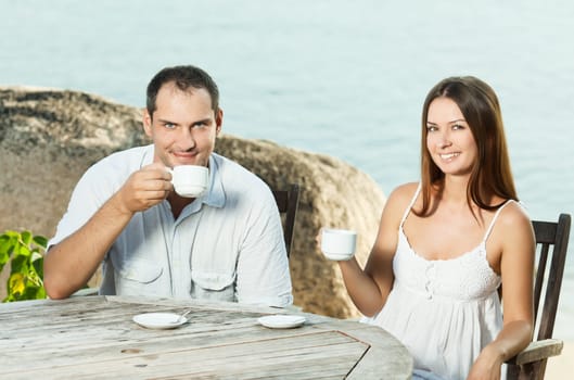 Young couple drinking a morning coffee outdoor
