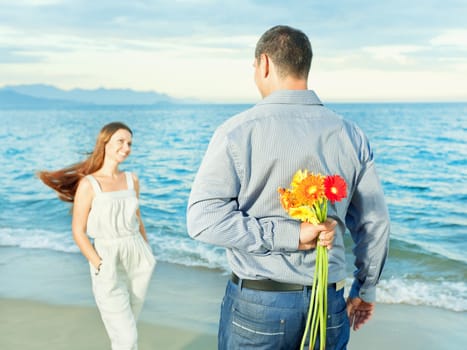 Man with flowers for his woman. Focus on a flowers