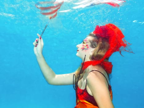 Woman with face art draws. Underwater shot