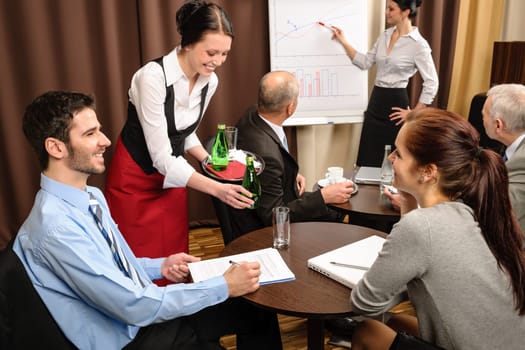 Waitress serving people at business meeting flipchart presentation