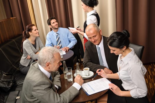 Business people having a company meeting at restaurant waitress ordering