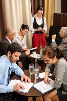Business people have company meeting at restaurant waitress ordering