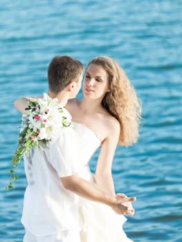 Bride and groom dancing on a rock.