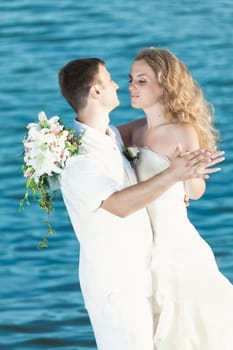 Bride and groom dancing on a rock.