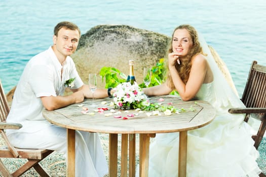 Bride and groom at wedding table near the sea