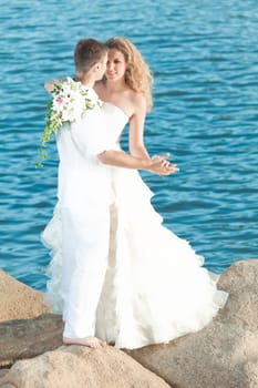 Bride and groom dancing on a rock.