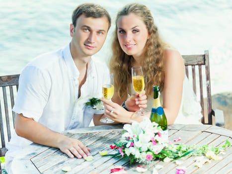 Bride and groom at wedding table near the sea