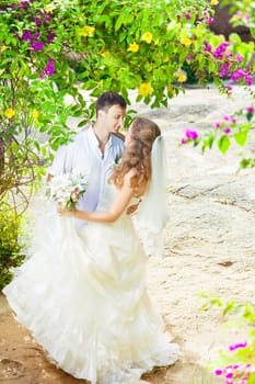 Bride and groom in a tropical garden