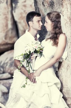 Bride and groom near the rock. Tropical wedding
