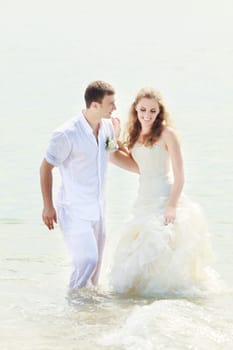 Bride and groom in the sea. Tropical wedding