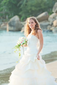 Bride with bouquet on the beach. Tropical wedding