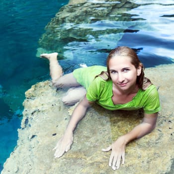Woman like mermaid in wet dress in lake