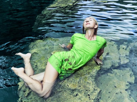 Woman like mermaid in wet dress in lake