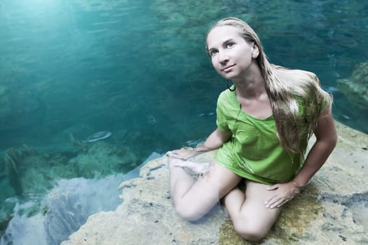 Woman like mermaid in wet dress in lake