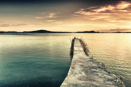 Sunrise over the sea. Pier on the foreground