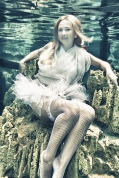Young beautiful woman in white dress underwater