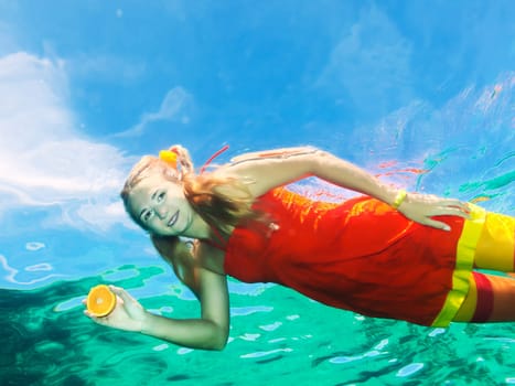 Underwater shot of a funny woman with orange