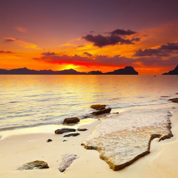 Sunset over the island. Stone on the foreground