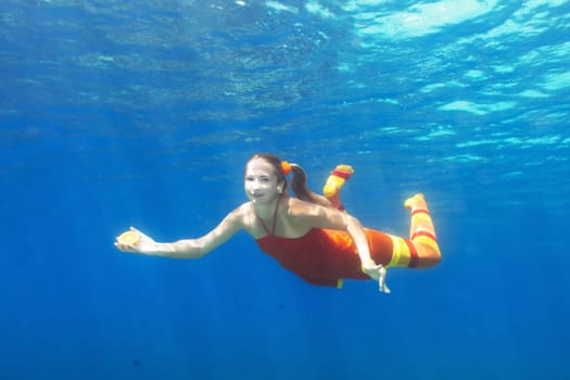 Underwater shot of a funny woman with orange