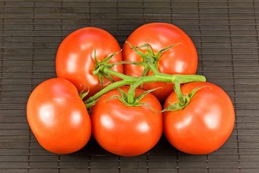 bunch of fresh tomatoes on black tablemat