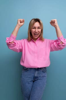 young pretty blond european office worker woman with flowing hair in a pink blouse smiles sweetly.