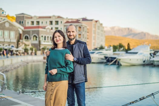 Couple in love tourists enjoying the views of Architecture and luxury yachts in Lustica Bay, Montenegro. Travel around Montenegro concept. Go Everywhere.