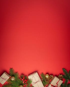 Christmas or New Year celebration red paper festive background with decoration fir tree, wrapped present boxes, cones, berries, sparkly red balls. Space for text..