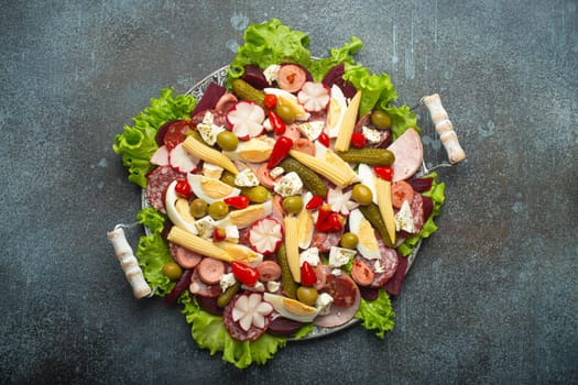 Fiambre, salad of Guatemala, Mexico and Latin America, served on large plate top view. Festive dish for All Saints Day (Day Of The Dead) celebration made of cold cuts, sausages, pickled vegetables.