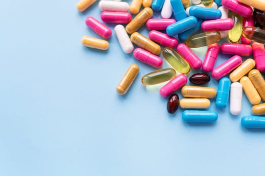 Medicine and healthcare concept. Macro shot of colorful bright tablets and capsules on a blue background. Place for an inscription