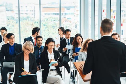 Group of business people meeting in a seminar conference . Audience listening to instructor in employee education training session . Office worker community summit forum with expert speaker . Jivy