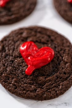 Freshly baked chocolate cookies with chocolate hearts for Valentine's Day.