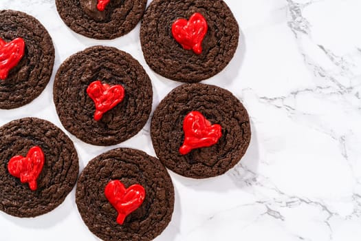 Freshly baked chocolate cookies with chocolate hearts for Valentine's Day.