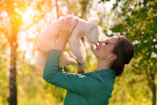 Young woman with her dog. Puppy white dog is running with it's owner. Concept about friendship and animal.