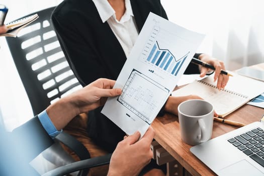 Diverse group of business analyst team analyzing financial data report paper on office table. Chart and graph dashboard by business intelligence analysis for strategic marketing planning Meticulous