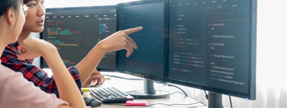 Cropped image of professional programer team collaboration discuss about web coding while coworker point java script displayed on computer at modern company office. Closeup. Burgeoning.