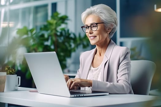 An old, successful woman works on a computer. High quality photo