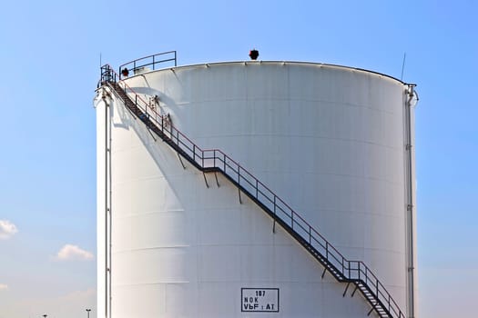 Big white industrial tank with blue sky