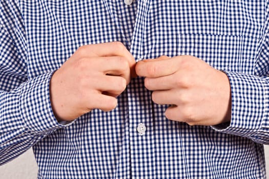 man closing his shirt