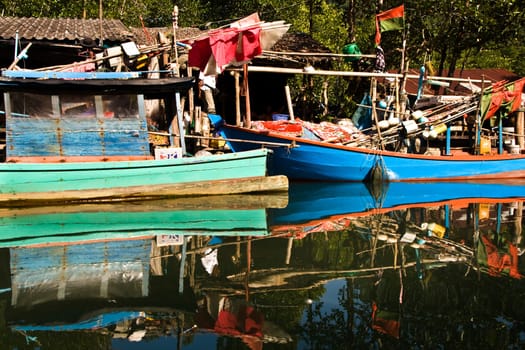 huts and colorful  fisherboats at the mangrove everglades in a small fishermans village in Koh Chang