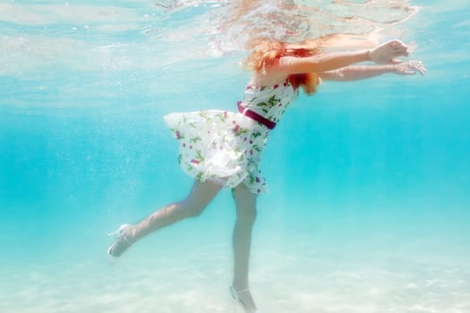 Young beautiful woman in white dress underwater