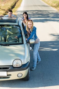 Vehicle breakdown young people pushing car down the road