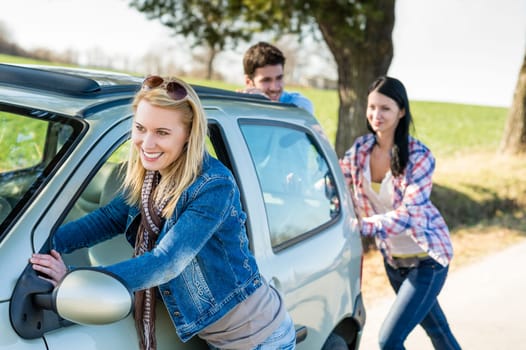 Vehicle breakdown young people pushing car down the road