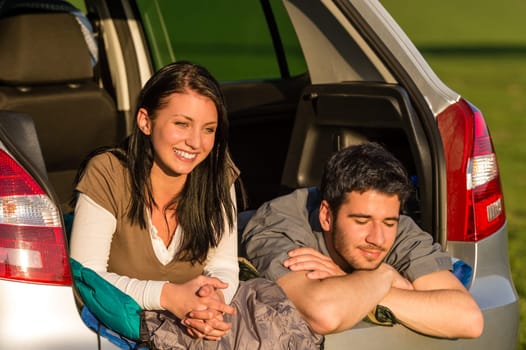 Camping young couple hugging together in car summer sunset