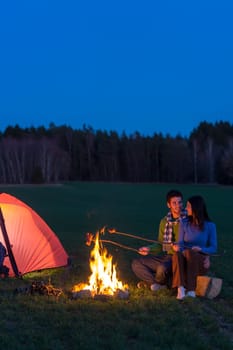 Camping night couple cook by campfire backpack in romantic countryside